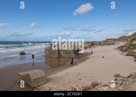 Touristes visitant des vestiges de bunkers depuis le mur de l'Atlantique à la plage de la mer du Nord de Løkken, Danemark Banque D'Images