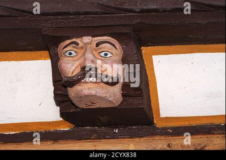 ENVY, l'un des sept péchés mortels du christianisme, représenté dans l'extrémité sculptée d'une poutre de plafond en bois qui dépasse de la Haus der Sieben Laster (Maison des sept vices) à Brückengasse 9 à Limburg an der Lahn, Hesse, Allemagne. L'ancienne maison, reconstruite en 1567, servait de maison familiale, de magasin de provisions, d'quincaillerie et de magasin de chaussures avant d'être rénovée à l'époque moderne et ouverte au public comme musée. Banque D'Images