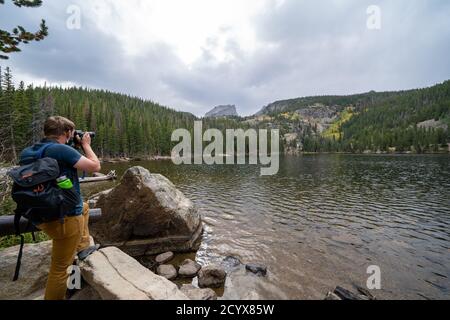 Colorado, États-Unis - 19 septembre 2020 : le photographe homme portant un masque prend des photos de Bear Lake dans le parc national des montagnes Rocheuses Banque D'Images