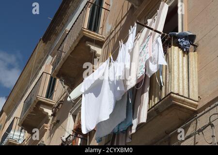 Lavage traîné au soleil sur un balcon dans la vieille ville de Trapani, Sicile Banque D'Images