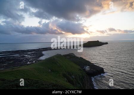 Coucher de soleil sur Gower Peninsular Rhossilli Bay Worm Rock formation rouge ciel Banque D'Images