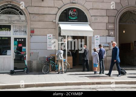 ROME, ITALIE - OCTOBRE 01 2020: Les clients, portant un masque de protection, attendent devant une pizzeria à Rome, Italie. Banque D'Images