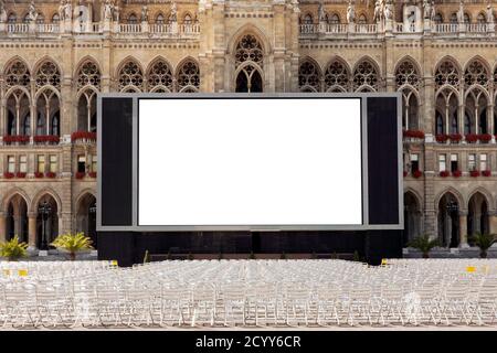 Écran vierge et chaises vides prêtes pour le cinéma en plein air devant un bâtiment historique décoratif à Vienne, Autriche Banque D'Images