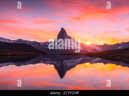 Paysage pittoresque avec le lever du soleil sur le lac Stellisee colorés. Snowy Matterhorn Cervino en crête avec reflet dans l'eau claire. Zermatt, Alpes Suisses Banque D'Images