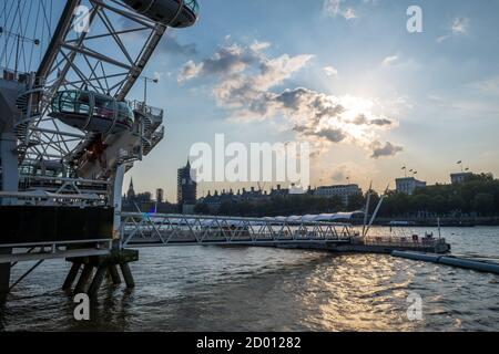 Le London Eye au bord de la Tamise et la Chambre du Parlement au coucher du soleil. Banque D'Images