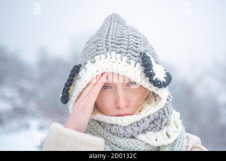 Allergie hiver saison. Femme ayant des maux de tête sur fond de neige. Banque D'Images