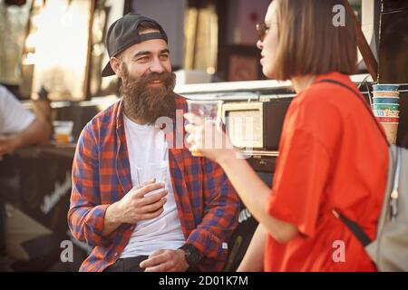 Un couple de Hipster se déchrée avec de la bière devant la nourriture chariot Banque D'Images