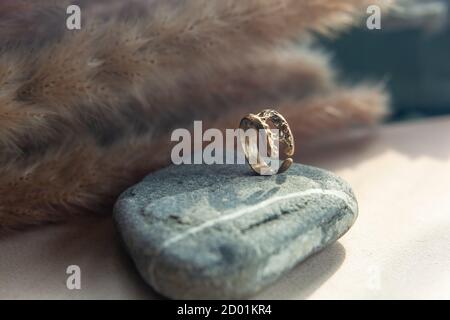 bague en laiton vintage tendance. bijoux bague femmes abstrait dessin gros plan sur une pierre naturelle grise avec des châles Banque D'Images