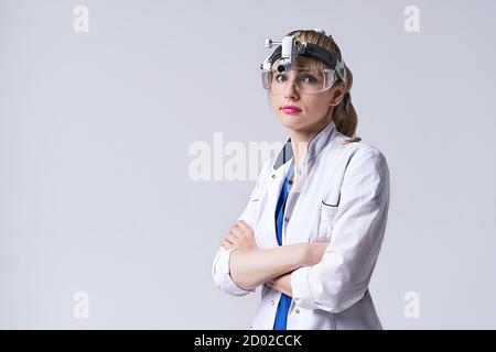 Médecin ORL confiant portant un phare chirurgical et des lunettes de protection. Portrait d'une otolaryngologiste féminine ou d'un chirurgien de la tête et du cou Banque D'Images