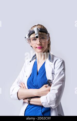 Médecin ORL confiant portant un phare chirurgical et des lunettes de protection. Portrait d'une otolaryngologiste féminine ou d'un chirurgien de la tête et du cou Banque D'Images