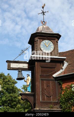 Abinger Hammer Clock surplombe la route principale et décrit la figure de 'Jack le forgeron', à la mémoire du premier seigneur Farrer de Abinger Hall qui Banque D'Images