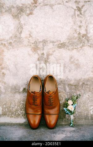 Chaussures brunes pour homme et boutonnière pour marié. Banque D'Images