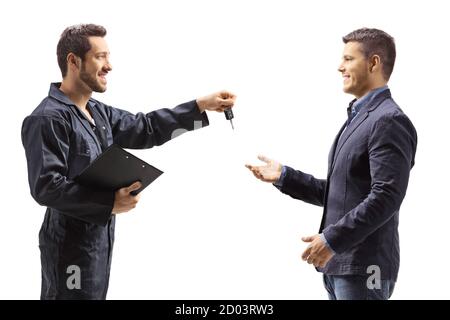 Mécanicien tenant un presse-papiers et donnant des clés à un client isolé sur fond blanc Banque D'Images