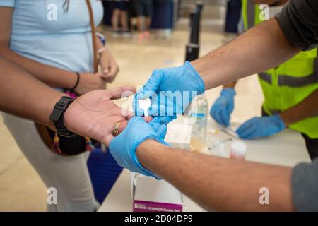 Cancun, Mexique. 1er octobre 2020. Un travailleur de la santé prélève un échantillon de sang auprès d'un passager pour effectuer un test rapide afin de détecter le SRAS-COV2 à l'origine de la coronavirus (Covid-19). De nouvelles mesures de sécurité sont prises dans les aéroports pour prévenir la propagation du virus à Cancun, au Mexique. (Photo par Eyepix Group/Pacific Press) crédit: Pacific Press Media production Corp./Alay Live News Banque D'Images