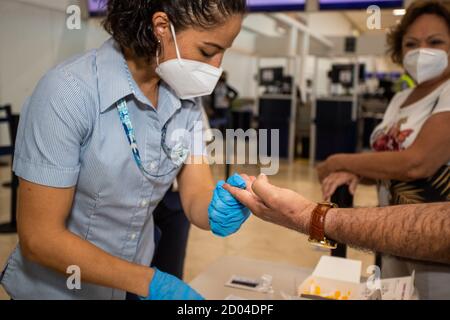 Cancun, Mexique. 1er octobre 2020. Un travailleur de la santé prélève un échantillon de sang auprès d'un passager pour effectuer un test rapide afin de détecter le SRAS-COV2 à l'origine de la coronavirus (Covid-19). De nouvelles mesures de sécurité sont prises dans les aéroports pour prévenir la propagation du virus à Cancun, au Mexique. (Photo par Eyepix Group/Pacific Press) crédit: Pacific Press Media production Corp./Alay Live News Banque D'Images