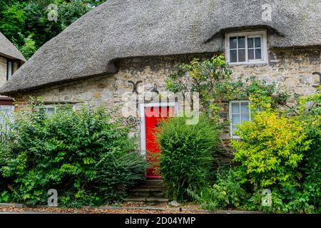 West Lulworth, Royaume-Uni - 19 juillet 2020: Belle maison de campagne en chaume avec porte et volets rouges, unique Dorset colorfull maison Banque D'Images