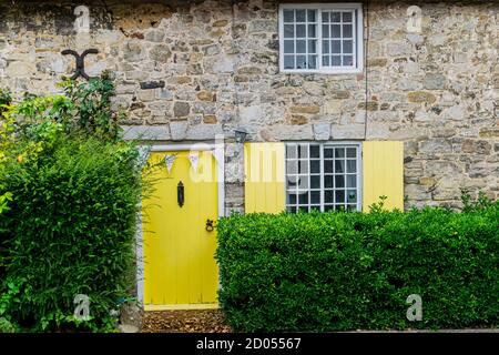 West Lulworth, Royaume-Uni - 19 juillet 2020: Belle maison de campagne en chaume avec porte et volets de couleur jaune, unique Dorset colorfull maison Banque D'Images