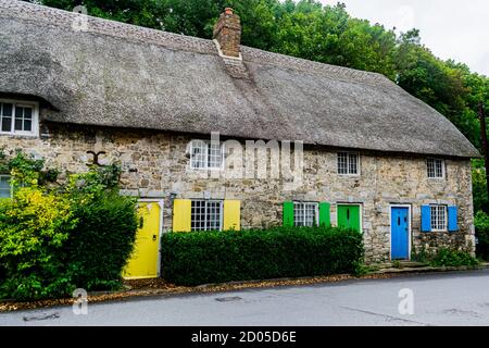 West Lulworth, Royaume-Uni - 19 juillet 2020: Belle maison de campagne en chaume avec portes et volets jaunes, verts et bleus, Dorset unique Banque D'Images