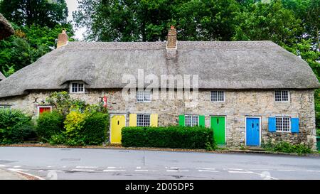 West Lulworth, Royaume-Uni - 19 juillet 2020: Belle maison de campagne en chaume avec portes et volets jaunes, verts et bleus, Dorset unique Banque D'Images