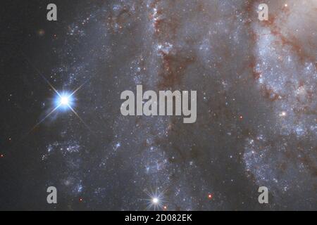 Ici, dans une image publiée le 1er octobre 2020, fait partie de la captivante galaxie NGC 2525. Située à près de 70 millions d'années-lumière de la Terre, cette galaxie fait partie de la constellation de Puppis dans l'hémisphère sud. Avec les constellations de Carina et de Vela, elle constitue une image de l'Argo de la mythologie grecque antique. Sur la gauche, une supernova brillante est visible sur l'image. La supernova est officiellement connue sous le nom de SN2018gv et a été repérée pour la première fois à la mi-janvier 2018. Le télescope spatial NASA/ESA Hubble a capturé la supernova dans le NGC 2525 dans le cadre d'une de ses principales enquêtes Banque D'Images