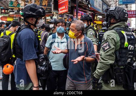 Un homme plaide auprès des policiers lors d'une manifestation interdite à Hong Kong, en Chine, le 1er octobre 2020. La police a déployé 6,000 officiers pendant le 71e anniversaire de la Journée nationale de la Chine pour contrer toute manifestation illégale et les assemblées à Hong Kong. Banque D'Images