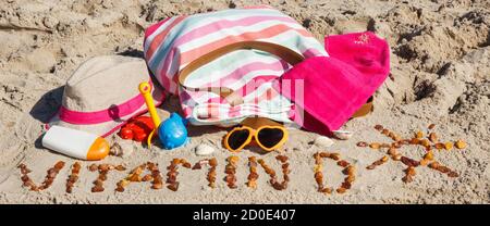 Inscription vitamine D avec forme de soleil, accessoires pour la détente et les enfants jouant sur le sable à la plage. Prévention de la carence en vitamine D. Banque D'Images