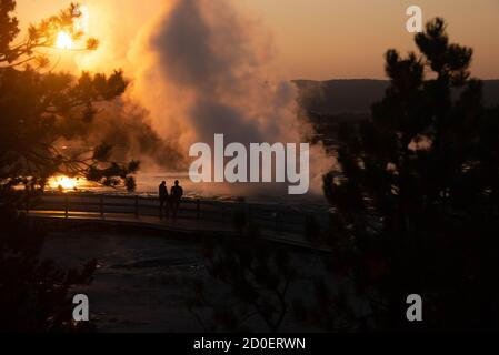 Le geyser de clopsydra éclate au coucher du soleil, bassin inférieur du Geyser, parc national de Yellowstone, Wyoming, États-Unis Banque D'Images