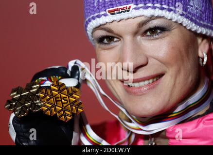 Bronze medal winner Maria Hoefl-Riesch of Germany presents her medals during the podium ceremony for the women's downhill race at the World Alpine Skiing Championships in Schladming February 10, 2013.  REUTERS/Dominic Ebenbichler (AUSTRIA - Tags: SPORT SKIING)