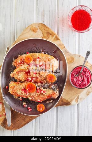 Poisson Gefilte avec carotte au raifort et vin de grenade sur une planche de bois sur fond blanc en bois. Un authentique plat juif. Pose à plat. Copier l'espace Banque D'Images