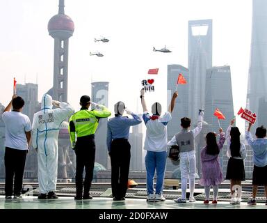 Pékin, Chine. 1er octobre 2020. Les gens saluent comme des hélicoptères avec le drapeau national chinois survole le fleuve Huangpu pour célébrer le 71e anniversaire de la fondation de la République populaire de Chine à Shanghai, en Chine orientale, le 1er octobre 2020. Credit: Chen Fei/Xinhua/Alay Live News Banque D'Images