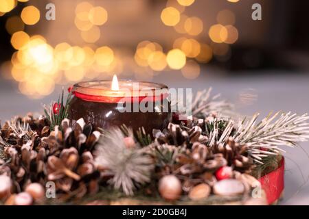 Décoration de Noël en branche d'arbre avec jouets du nouvel an sur elle et une bougie dans elle. Banque D'Images
