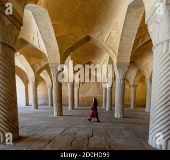 Shiraz, Iran - 2019-04-08 - Femme promenades par colonnes cannelées de mosquée Vakil. Banque D'Images