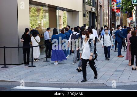 TOKYO, JAPON - 30 septembre 2020 : rue à l'extérieur de l'Apple Store de Ginza où le personnel traite les personnes qui attendent d'entrer. Les gens portent des masques et des rp Banque D'Images