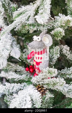 Symbole de l'année 2020. Rat jouet blanc dans un chapeau de noël suspendu sur un arbre en fourrure enneigé. Décoration intérieure festive. Banque D'Images