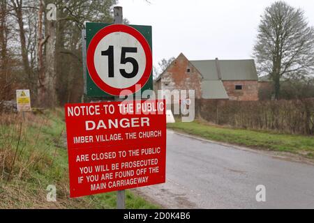 Maisons et un panneau d'avertissement à Imber Village partie du terrain d'entraînement militaire à Salisbury Plain, Wiltshire, Angleterre, Royaume-Uni Banque D'Images