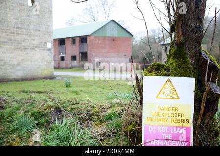 Maisons et un panneau d'avertissement à Imber Village partie du terrain d'entraînement militaire à Salisbury Plain, Wiltshire, Angleterre, Royaume-Uni Banque D'Images