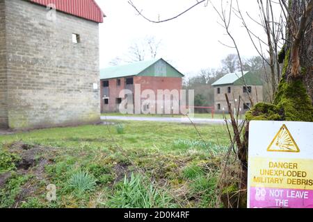 Maisons et un panneau d'avertissement à Imber Village partie du terrain d'entraînement militaire à Salisbury Plain, Wiltshire, Angleterre, Royaume-Uni Banque D'Images