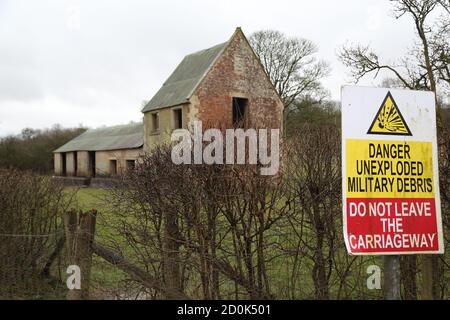 Maisons et un panneau d'avertissement à Imber Village partie du terrain d'entraînement militaire à Salisbury Plain, Wiltshire, Angleterre, Royaume-Uni Banque D'Images