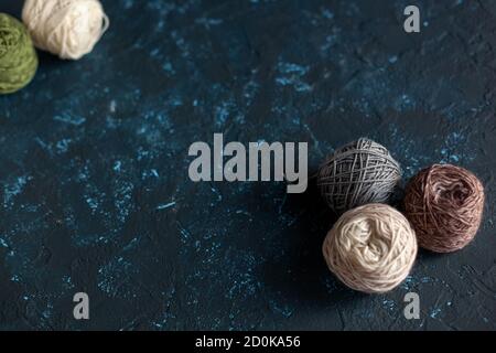 Balles de couleur pelote de fil de laine pour crochet et tricotage sur béton de mastic de texture bleu foncé. Mettre à plat l'image avec de l'espace pour le texte. Banque D'Images