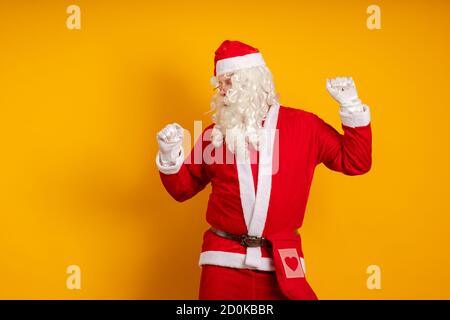 Acteur masculin dans un costume de Santa Claus dansant et gestuelle Banque D'Images