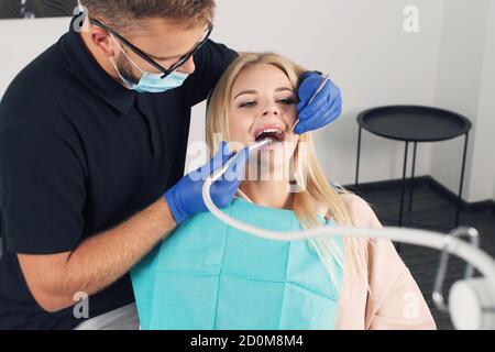 Portrait d'un dentiste qui traite les dents de jeune femme patient. Banque D'Images