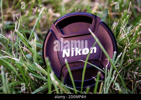 Chapeau d'appareil photo reflex Nikon photographié dans l'herbe. Banque D'Images