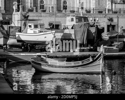 Petit port de la Valette capitale de l'île de Malte avec les bateaux de pêche typiques en bois. Banque D'Images