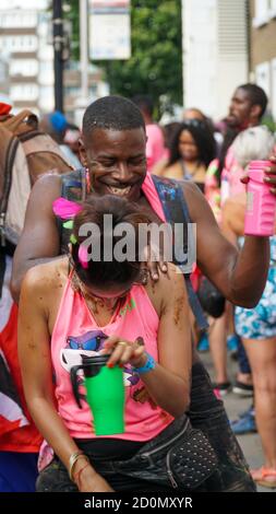 Couple diversifié dansant et riant au Carnaval de Notting Hill à Londres, Royaume-Uni Banque D'Images