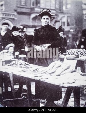 Une jeune femme qui vend des huîtres fraîchement pêchées et pêchait au large d'une barrow dans la station de vacances populaire de Scarborough, North Yorkshire, Royaume-Uni, vers 1895. Les huîtres étaient un aliment de base en Grande-Bretagne, en particulier pour les pauvres Banque D'Images