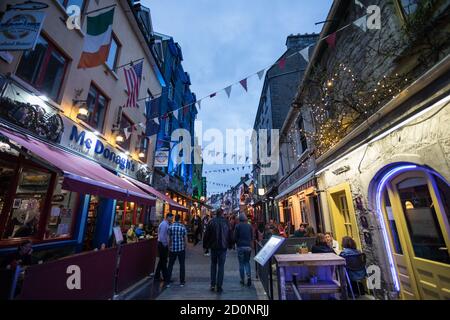 GALWAY CITY, IRLANDE - 4 mai, 2018: Personnes appréciant des bars et des restaurants sur la rue Quay dans le quartier latin populaire de la ville de Galway la nuit. Banque D'Images