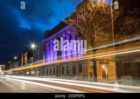 Cork City, Irlande - 22 avril 2018 : traînées légères de voitures et bus passant devant le bâtiment de la banque irlandaise Allied sur la rue South Mall dans la ville de Cork Banque D'Images