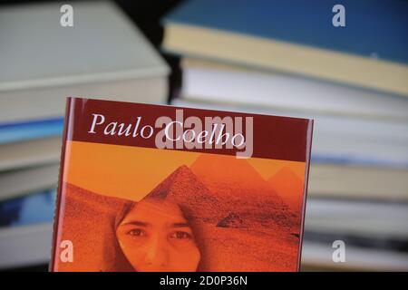 Viersen, Allemagne - mai 9. 2020: Vue sur la couverture de livre isolée de Paulo Coelho l'alchimiste avec pile de livres fond Banque D'Images