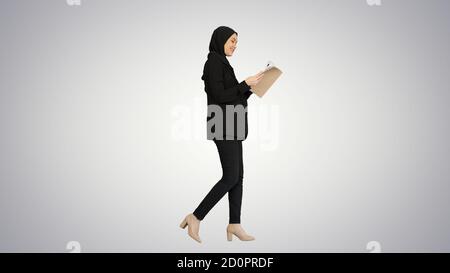 Surprise femme d'affaires musulmane lisant le journal d'affaires et de s'en tenir Banque D'Images