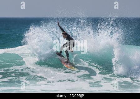 Une action spectaculaire en tant que jeune surfeur fait une vague à Fistral à Newquay, en Cornouailles. Banque D'Images